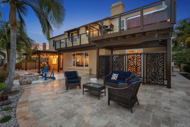 7661 Sitio Algodon, Carlsbad, CA 92009 - rear view of house with a balcony, stucco siding, a patio area, an outdoor living space with a fire pit, and a chimney