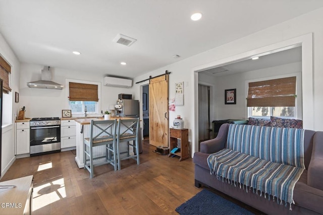 310 N Fulton St, Ojai, CA 93023 - living area with an AC wall unit, a barn door, dark wood-style floors, and recessed lighting