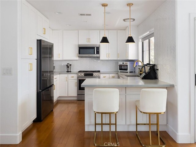 22477 Kent, Torrance, CA 90505 - kitchen with stainless steel appliances, a peninsula, tasteful backsplash, white cabinetry, and a breakfast bar area