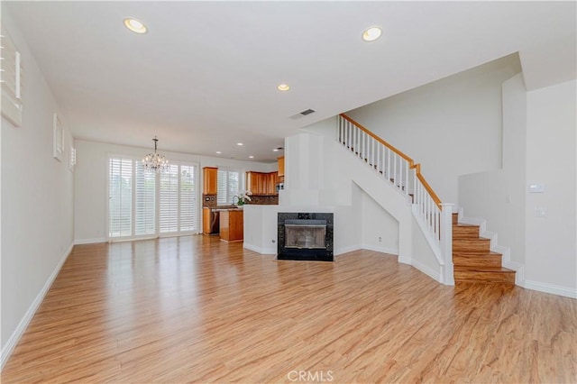 24646 Maple Ln, Harbor City, CA 90710 - unfurnished living room with a chandelier, light wood-type flooring, stairway, recessed lighting, and a fireplace