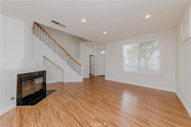 24646 Maple Ln, Harbor City, CA 90710 - unfurnished living room with light wood-type flooring, stairs, recessed lighting, and a high end fireplace