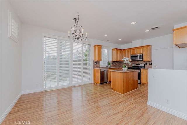 24646 Maple Ln, Harbor City, CA 90710 - kitchen with appliances with stainless steel finishes, light wood-style flooring, backsplash, a chandelier, and light countertops