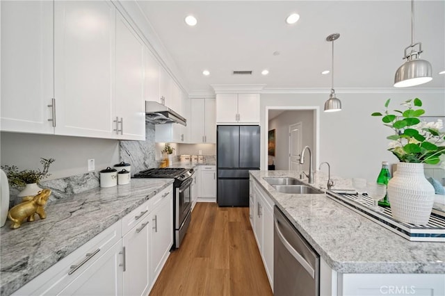 89 Overbrook, Irvine, CA 92620 - kitchen with stainless steel appliances, under cabinet range hood, white cabinets, light wood-style floors, and pendant lighting
