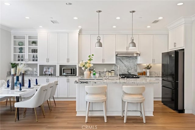 89 Overbrook, Irvine, CA 92620 - kitchen featuring freestanding refrigerator, a kitchen island with sink, white cabinetry, ornamental molding, and recessed lighting