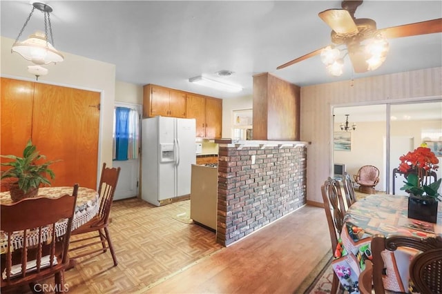 8707 Chester St, Paramount, CA 90723 - kitchen with white fridge with ice dispenser, ceiling fan, a peninsula, brown cabinetry, and parquet floors