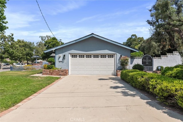 6210 Riverside Ave, Rialto, CA 92377 - view of front facade featuring concrete driveway, a front lawn, an attached garage, stucco siding, and a gate
