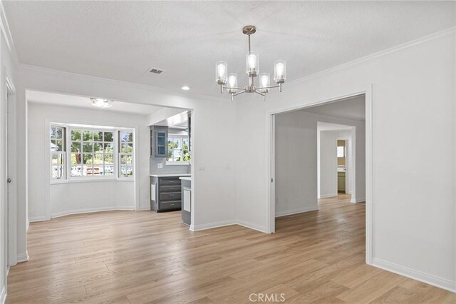 6210 Riverside Ave, Rialto, CA 92377 - empty room with a chandelier, light wood finished floors, ornamental molding, and a textured ceiling