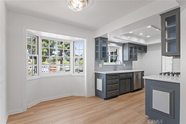 6210 Riverside Ave, Rialto, CA 92377 - kitchen with light wood-style floors, stainless steel appliances, glass insert cabinets, light countertops, and recessed lighting