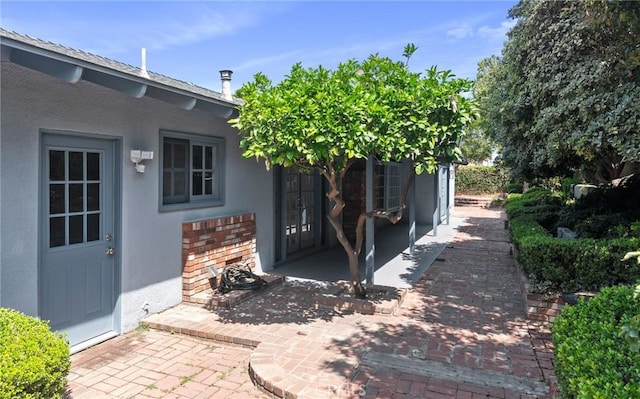 6210 Riverside Ave, Rialto, CA 92377 - doorway to property featuring stucco siding, french doors, and brick siding