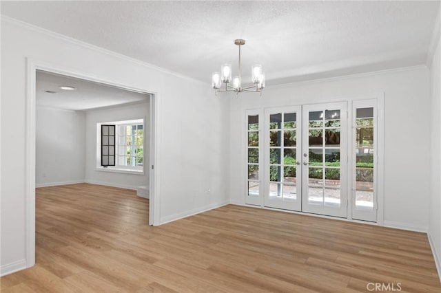 6210 Riverside Ave, Rialto, CA 92377 - spare room featuring a chandelier, light wood-style floors, ornamental molding, a textured ceiling, and french doors