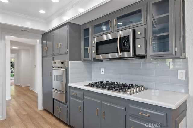 6210 Riverside Ave, Rialto, CA 92377 - kitchen with stainless steel appliances, a warming drawer, crown molding, light wood-type flooring, and backsplash