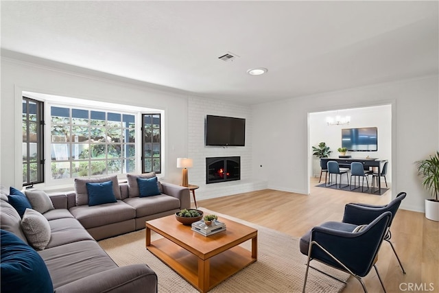 6210 Riverside Ave, Rialto, CA 92377 - living area featuring a chandelier, ornamental molding, light wood finished floors, a fireplace, and recessed lighting