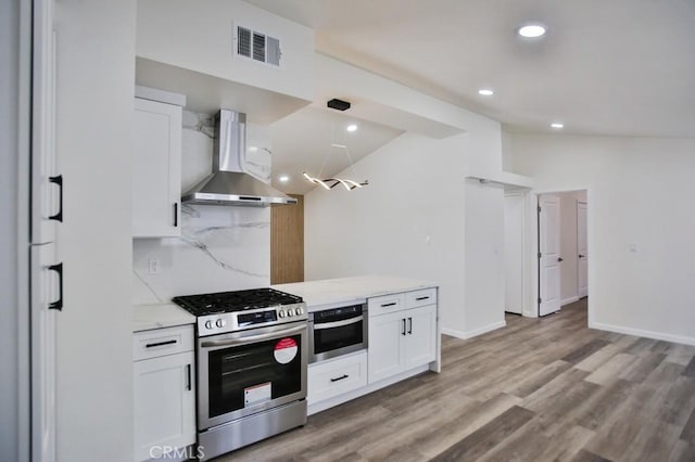 13282 Cherry St, Westminster, CA 92683 - kitchen featuring wall chimney range hood, appliances with stainless steel finishes, white cabinetry, tasteful backsplash, and light wood finished floors