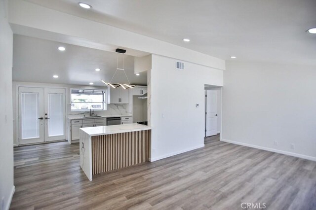 13282 Cherry St, Westminster, CA 92683 - kitchen featuring stainless steel dishwasher, wood finished floors, light countertops, recessed lighting, and decorative backsplash