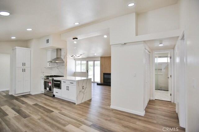 13282 Cherry St, Westminster, CA 92683 - kitchen featuring wall chimney range hood, stainless steel gas range oven, white cabinetry, light wood finished floors, and recessed lighting