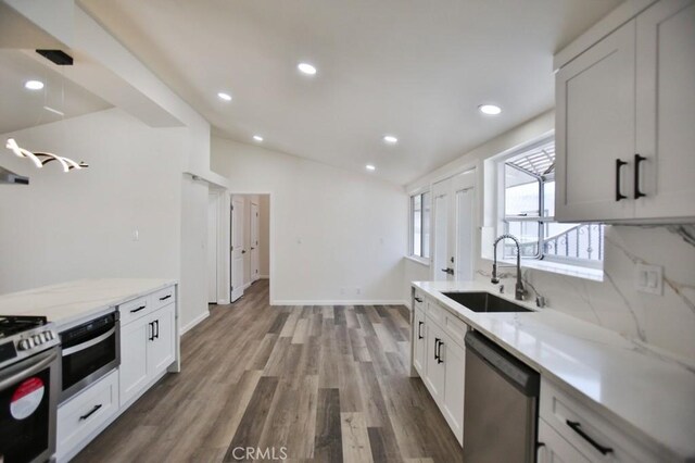 13282 Cherry St, Westminster, CA 92683 - kitchen with appliances with stainless steel finishes, wood finished floors, light stone counters, vaulted ceiling, and recessed lighting