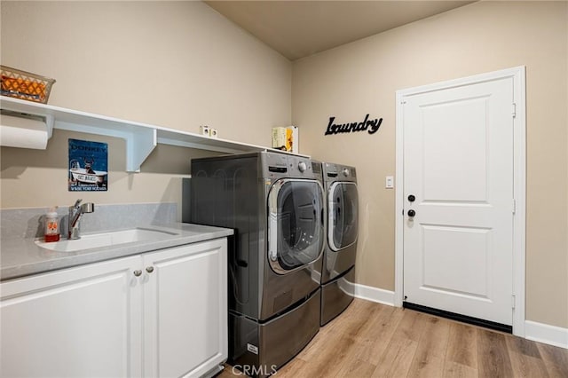 24420 Crooked Trail Dr, Menifee, CA 92584 - washroom with washer and dryer, cabinet space, and light wood-type flooring