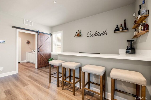24420 Crooked Trail Dr, Menifee, CA 92584 - indoor dry bar with a barn door and light wood-style floors