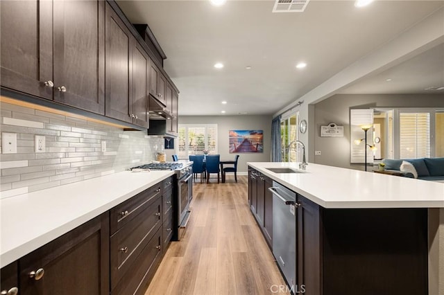 24420 Crooked Trail Dr, Menifee, CA 92584 - kitchen featuring stainless steel appliances, light wood-style floors, recessed lighting, light countertops, and backsplash