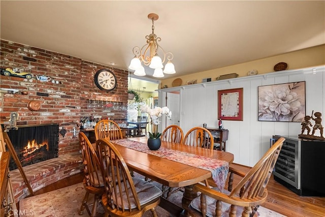 9214 Mclennan Ave, Northridge, CA 91343 - dining space with wood finished floors, a chandelier, beverage cooler, and a brick fireplace