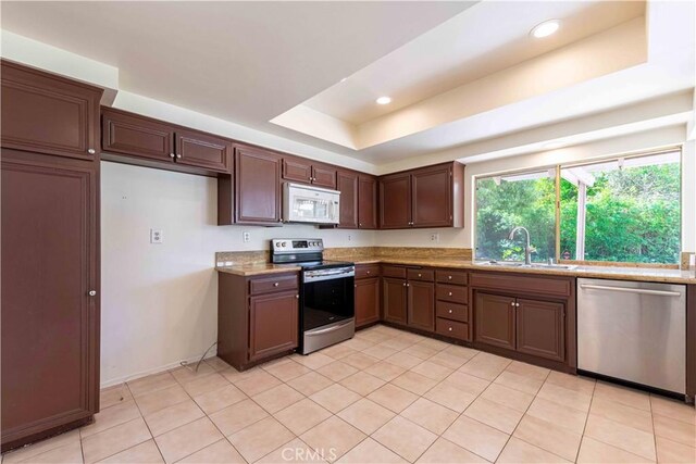 28752 Pisces St, Agoura Hills, CA 91301 - kitchen featuring stainless steel appliances, light tile patterned flooring, light stone counters, a tray ceiling, and recessed lighting