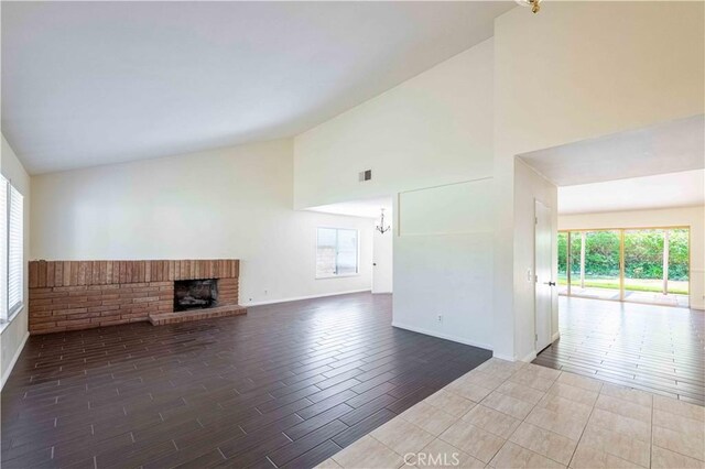 28752 Pisces St, Agoura Hills, CA 91301 - unfurnished living room featuring high vaulted ceiling, a fireplace, wood finished floors, and a chandelier