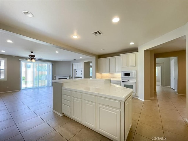 41926 Bonita Dr, Palmdale, CA 93551 - kitchen featuring tile counters, light tile patterned floors, white appliances, ceiling fan, and white cabinets