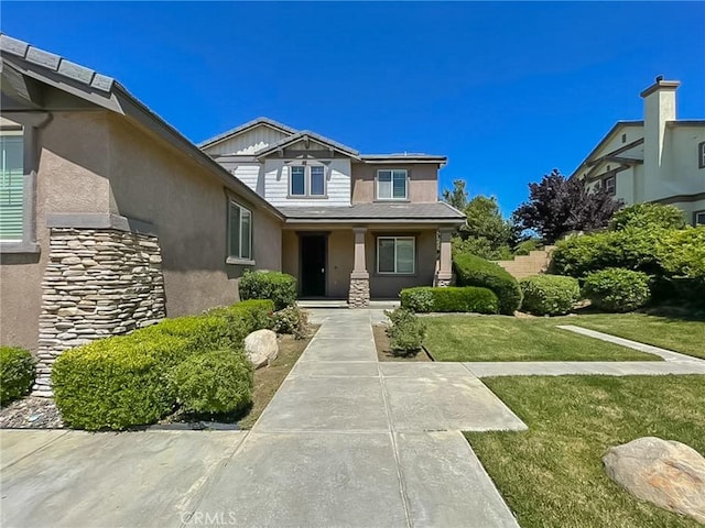 41926 Bonita Dr, Palmdale, CA 93551 - view of exterior entry featuring stone siding, covered porch, stucco siding, and a lawn