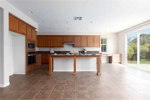 30315 Laruns St, Murrieta, CA 92563 - kitchen with appliances with stainless steel finishes, dark countertops, recessed lighting, brown cabinets, and tile patterned flooring