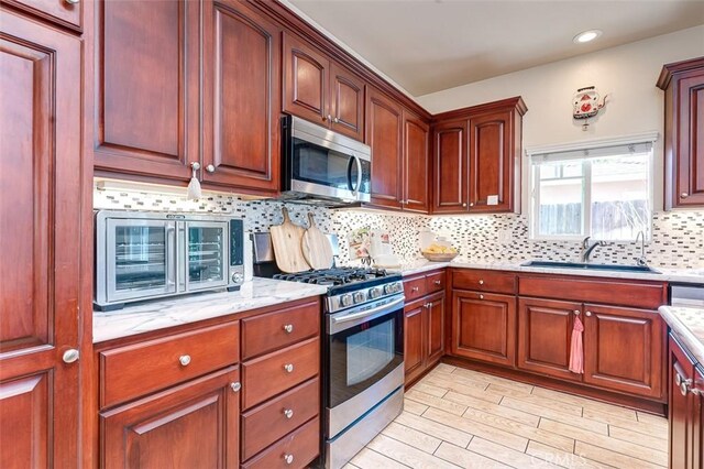 335 E Francis Ave, La Habra, CA 90631 - kitchen with appliances with stainless steel finishes, light wood-type flooring, decorative backsplash, recessed lighting, and light stone countertops