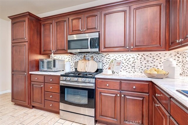 335 E Francis Ave, La Habra, CA 90631 - kitchen featuring appliances with stainless steel finishes, decorative backsplash, and light wood finished floors