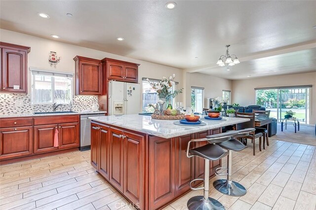 335 E Francis Ave, La Habra, CA 90631 - kitchen featuring white fridge with ice dispenser, dishwasher, light wood finished floors, a kitchen island, and a breakfast bar area