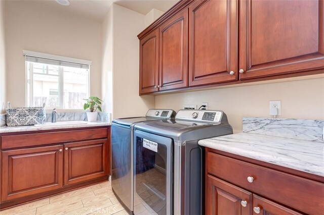 335 E Francis Ave, La Habra, CA 90631 - washroom with cabinet space, washer and clothes dryer, and light wood-style flooring