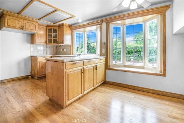 1129 Belbury Dr, Walnut, CA 91789 - kitchen featuring healthy amount of natural light, light wood-type flooring, glass insert cabinets, and decorative backsplash
