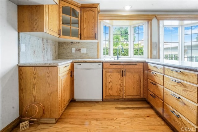 1129 Belbury Dr, Walnut, CA 91789 - kitchen featuring white dishwasher, light wood-style floors, light countertops, glass insert cabinets, and backsplash