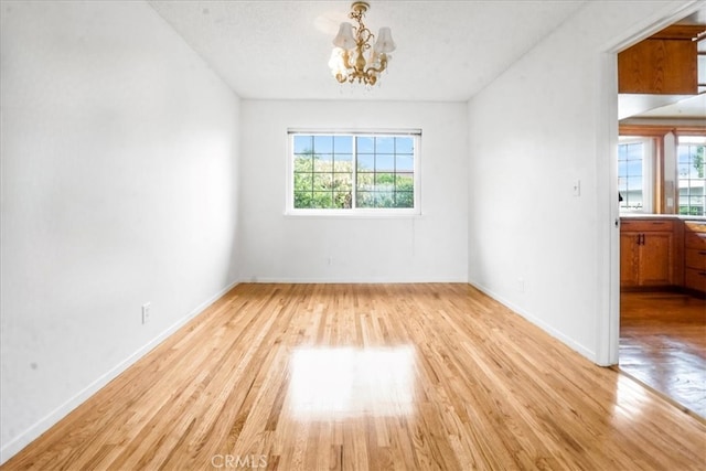 1129 Belbury Dr, Walnut, CA 91789 - spare room featuring plenty of natural light, light wood-style flooring, and a chandelier