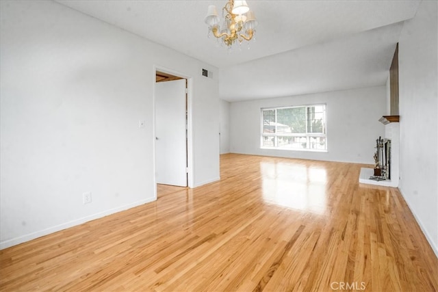 1129 Belbury Dr, Walnut, CA 91789 - unfurnished living room featuring a chandelier, light wood-style flooring, and a brick fireplace