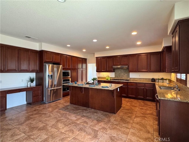 33314 Lazurite Way, Menifee, CA 92584 - kitchen with stainless steel appliances, under cabinet range hood, light stone countertops, a kitchen island, and recessed lighting