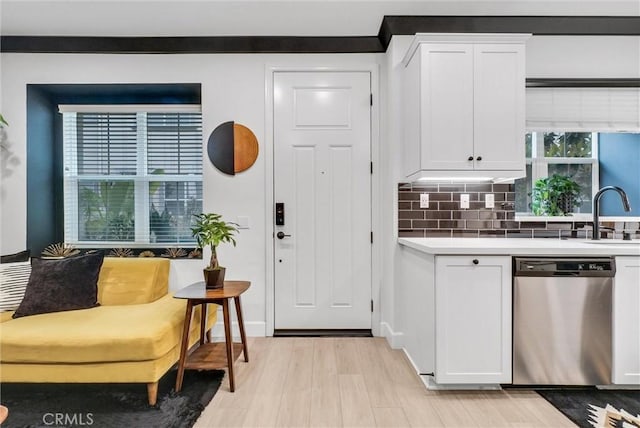 12342 Blue Sky Ct, Whittier, CA 90602 - kitchen with stainless steel dishwasher, white cabinetry, and decorative backsplash
