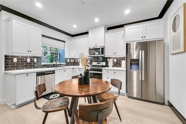 12342 Blue Sky Ct, Whittier, CA 90602 - kitchen with appliances with stainless steel finishes, light countertops, tasteful backsplash, white cabinetry, and light wood-style floors