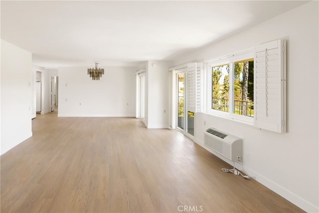2386 Via Mariposa W Unit 2B, Laguna Woods, CA 92637 - unfurnished living room with a chandelier, light wood-type flooring, and an AC wall unit