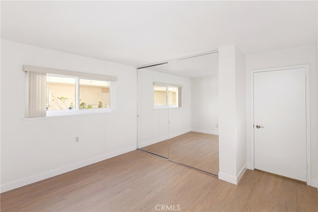 2386 Via Mariposa W Unit 2B, Laguna Woods, CA 92637 - unfurnished bedroom featuring light wood-style flooring, a closet, and multiple windows