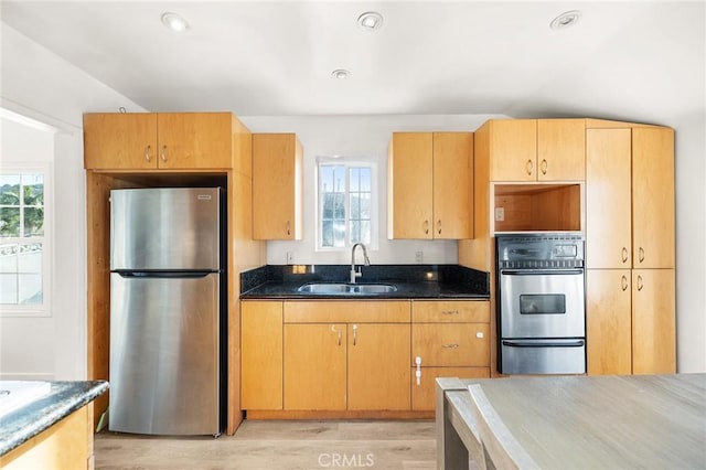 1517 W Grand Ave, Pomona, CA 91766 - kitchen featuring appliances with stainless steel finishes, a warming drawer, light wood-style floors, and dark stone counters