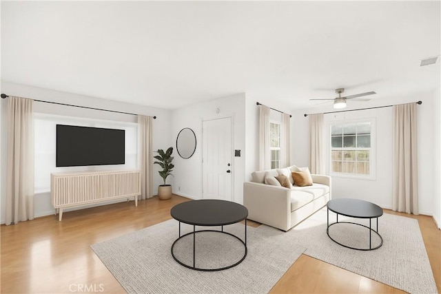 1517 W Grand Ave, Pomona, CA 91766 - living room with light wood-style floors, radiator, and a ceiling fan