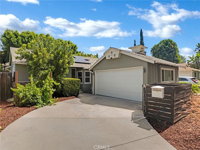 15017 Archwood St, Van Nuys, CA 91405 - view of front of home with an attached garage, solar panels, concrete driveway, and stucco siding