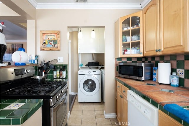 2561 E Washington St, Carson, CA 90810 - kitchen featuring stainless steel appliances, washer / dryer, decorative backsplash, ornamental molding, and tile countertops