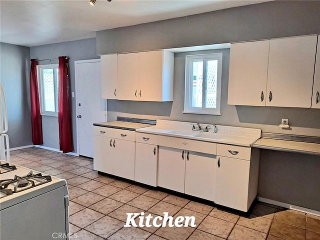 1920 Flora, Needles, CA 92363 - kitchen with light countertops, white cabinets, white gas stove, and light tile patterned floors