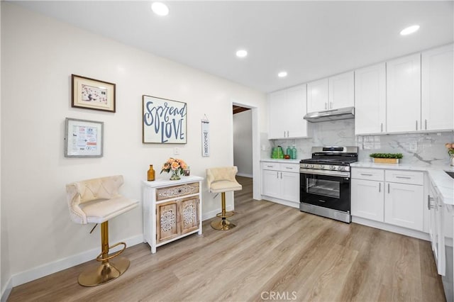4003 Puente Ave, Baldwin Park, CA 91706 - kitchen featuring stainless steel range with gas stovetop, under cabinet range hood, light wood-style floors, white cabinetry, and recessed lighting