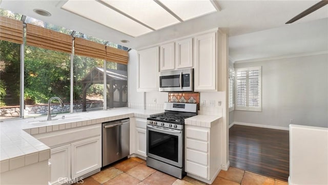 31850 Camino Marea, Temecula, CA 92592 - kitchen with appliances with stainless steel finishes, tile counters, white cabinets, and crown molding