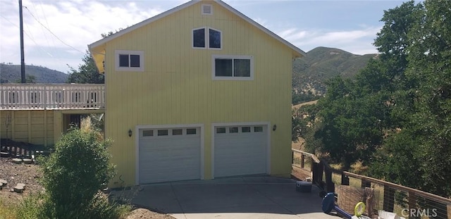 2723 Apache Trl, Clearlake Oaks, CA 95423 - view of home's exterior with a mountain view, a garage, and driveway